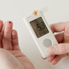 Hands holding glucometer with reading