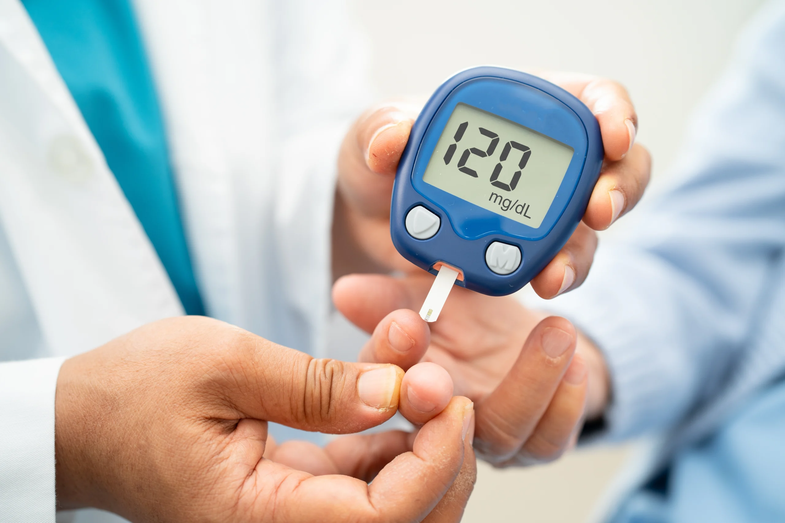 Close-up of a glucose meter in hand measuring blood