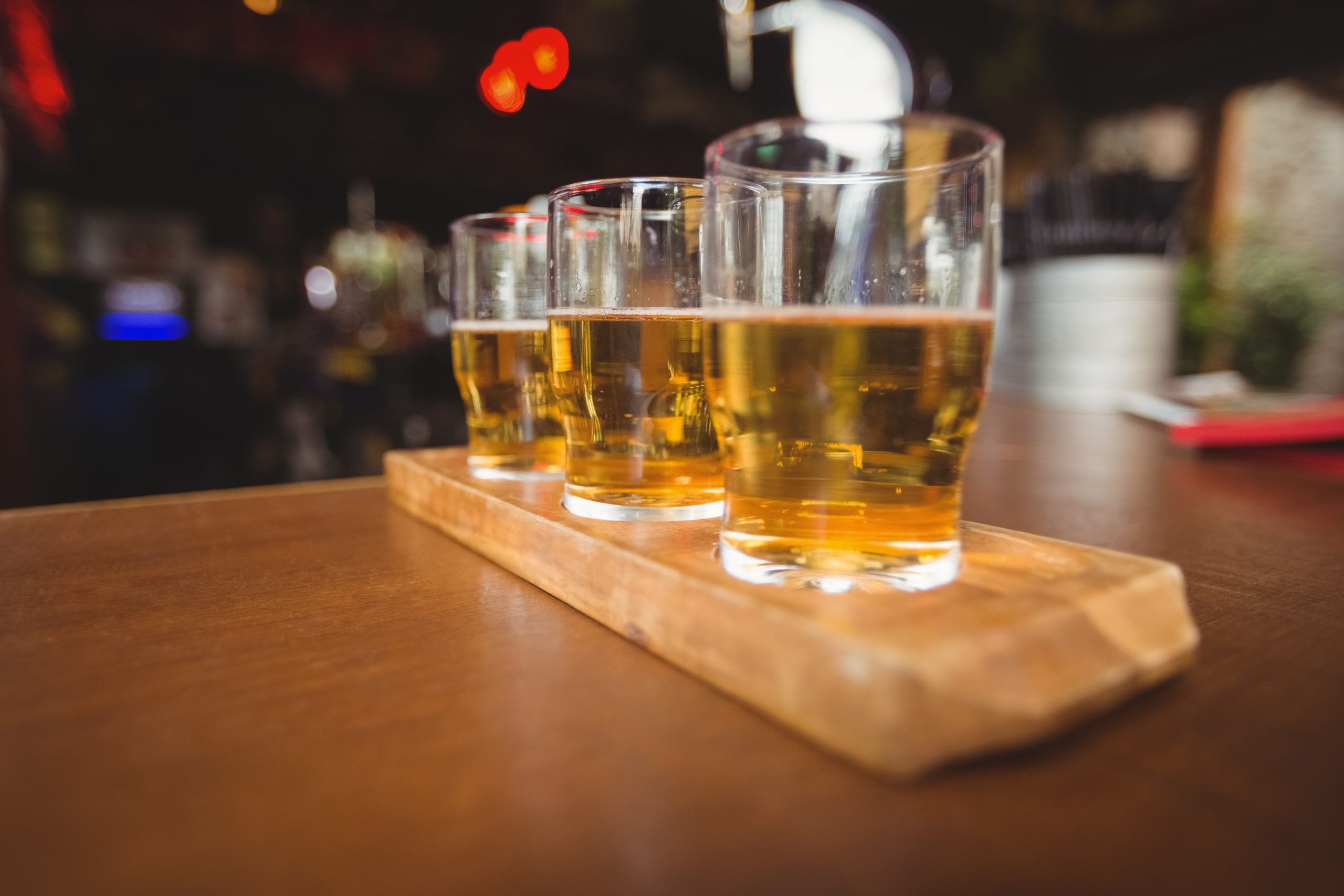 Close-up of beer glasses on a bar counter, illustrating the guide on drinking alcohol while taking semaglutide for weight loss.