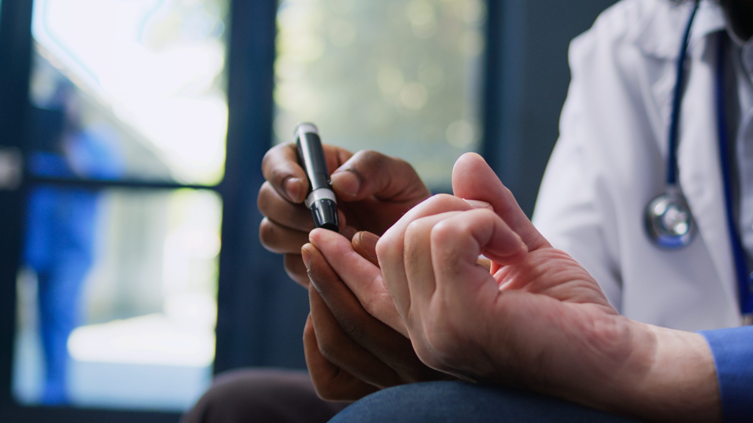 Doctor holding a pen while examining his phone, highlighting the importance of proper glucometer calibration.
