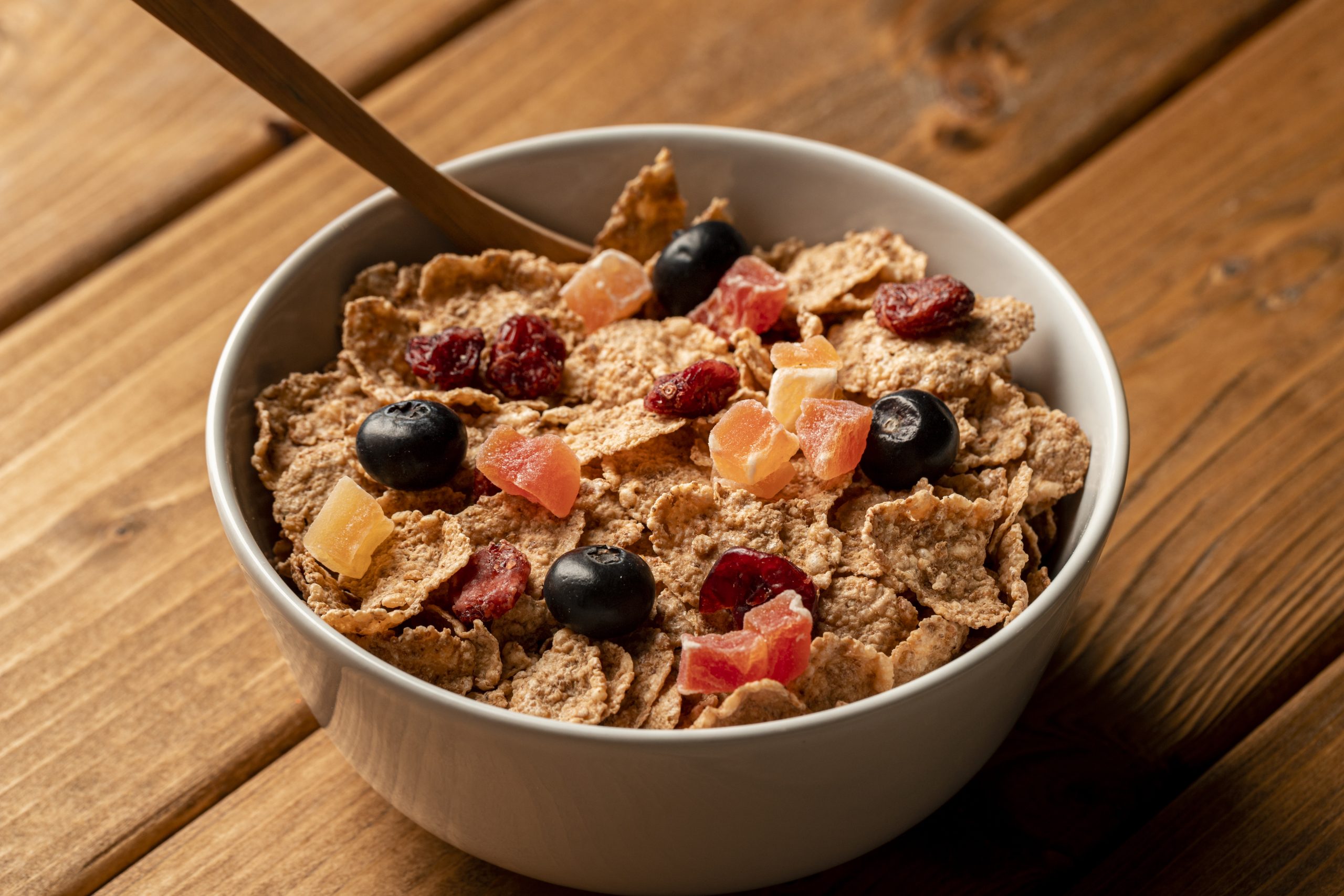 Bowl of granola with dried fruits and blueberries on a wooden table, illustrating whether granola is good for diabetics.